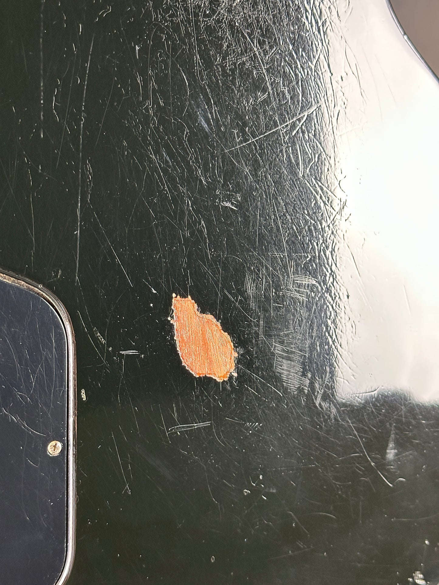 Scratched black surface with a small brown patch