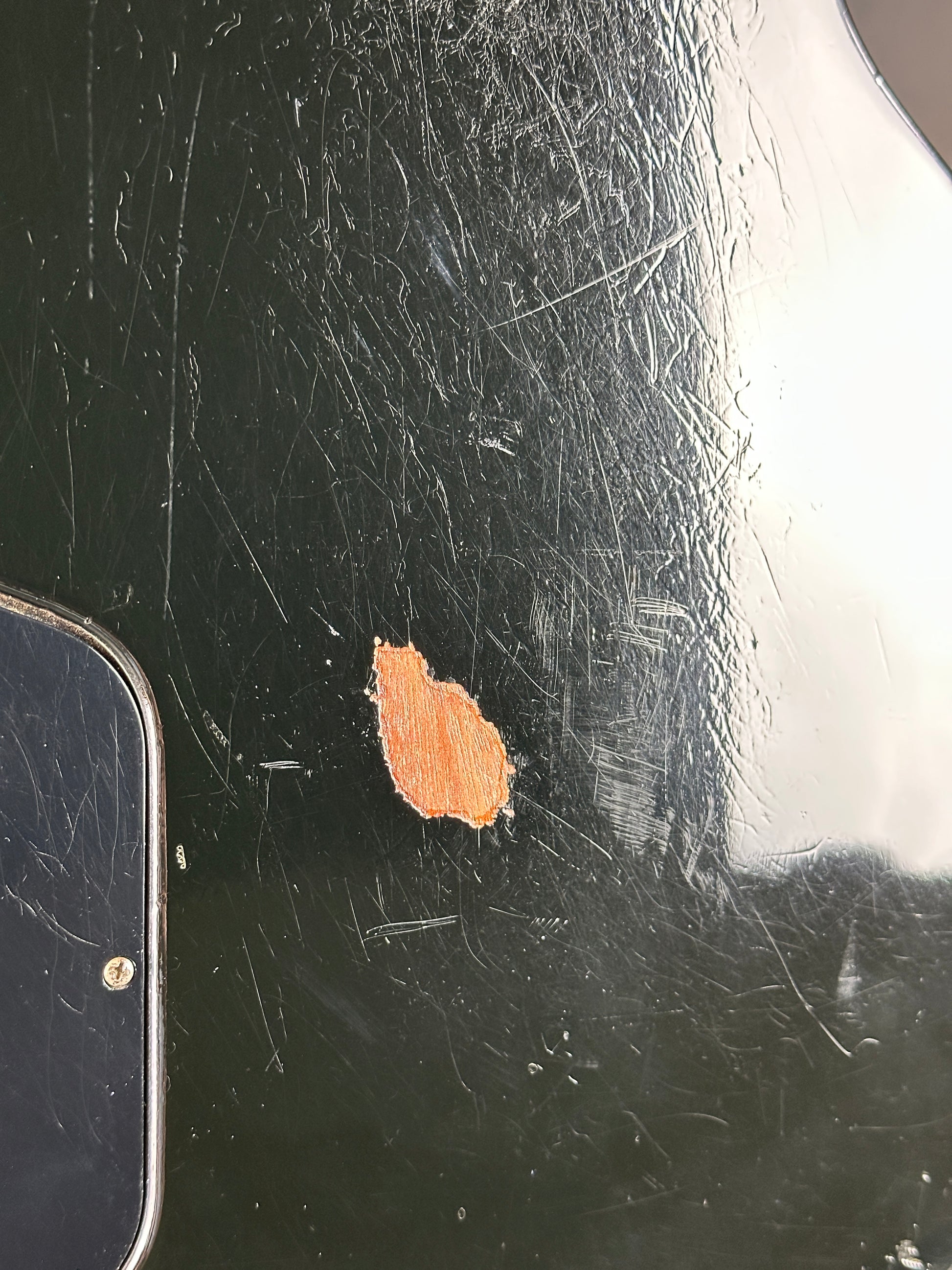 Scratched black surface with a small brown patch