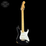 A classic Fender Stratocaster electric guitar with a black body, white pickguard, and natural maple neck, shown against a solid black background. A 'Tone Shop' watermark is visible in the top-left corner.