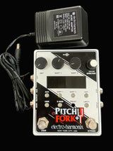 Electro-Harmonix Pitch Fork+ guitar effects pedal with power supply on a black background