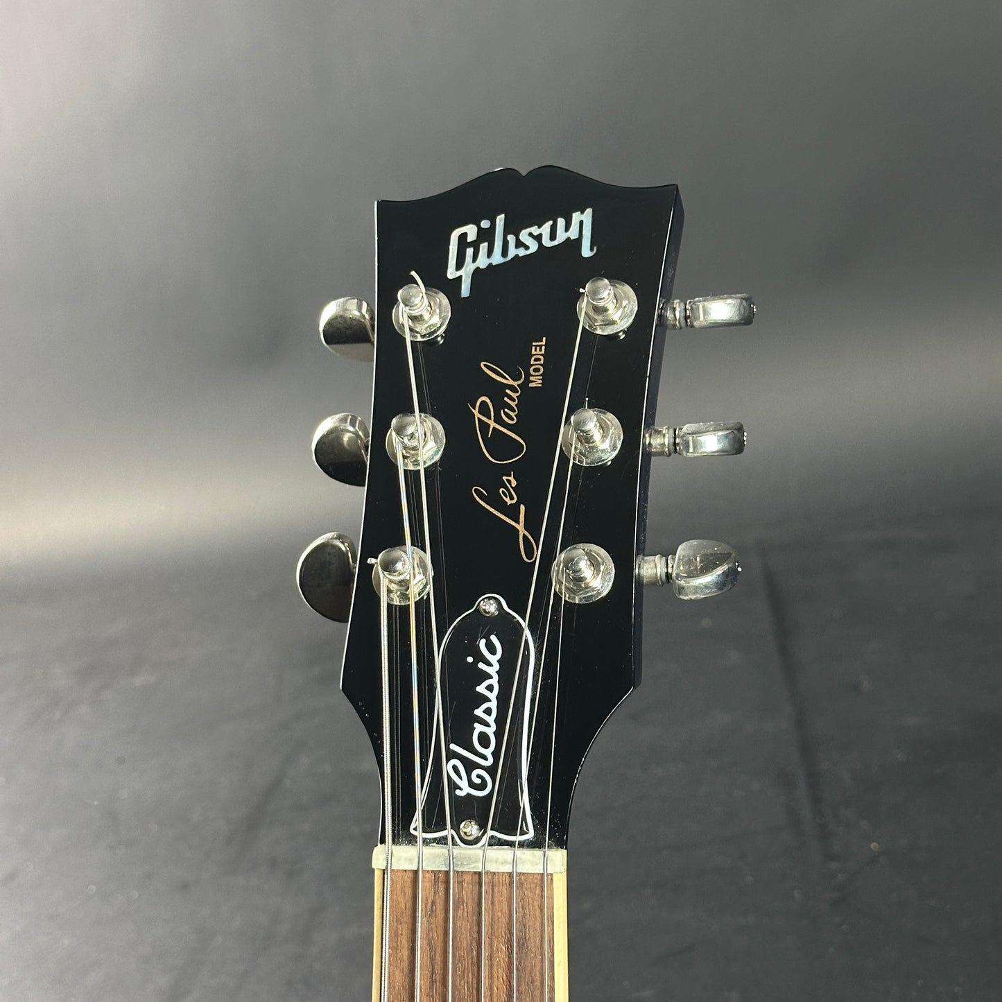 Gibson Les Paul guitar headstock on a gray background