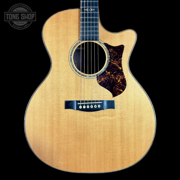Acoustic guitar with a cutaway on a black background, featuring the Tone Shop logo.