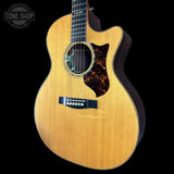 Acoustic guitar with a visible brand logo on a black background