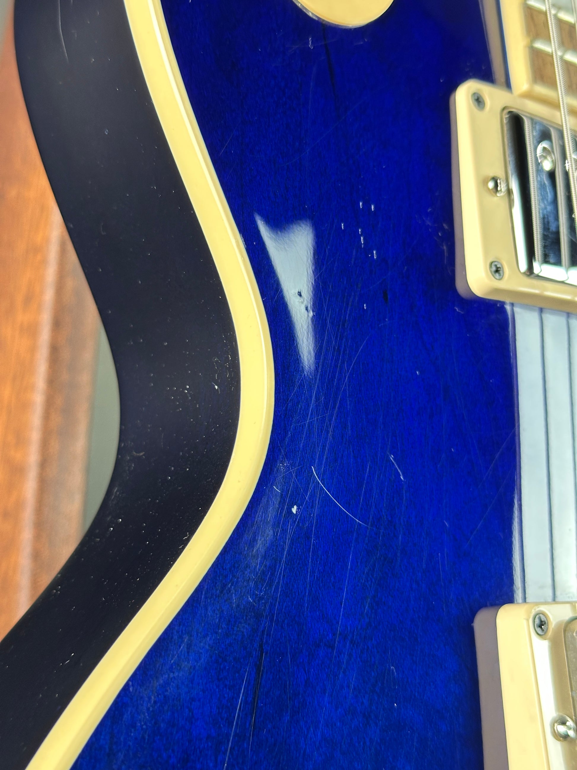 Close-up of a blue electric guitar with visible wear and tear.