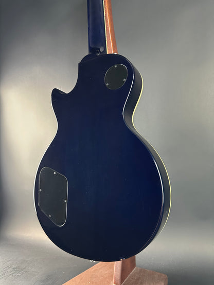 Blue electric guitar on a gray surface with a neutral background