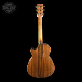 Back view of a wooden acoustic guitar on a black background with 'Tone Shop' logo.