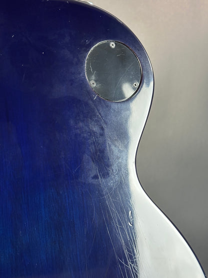 Close-up of a blue and silver object with scratches and a circular metallic component.