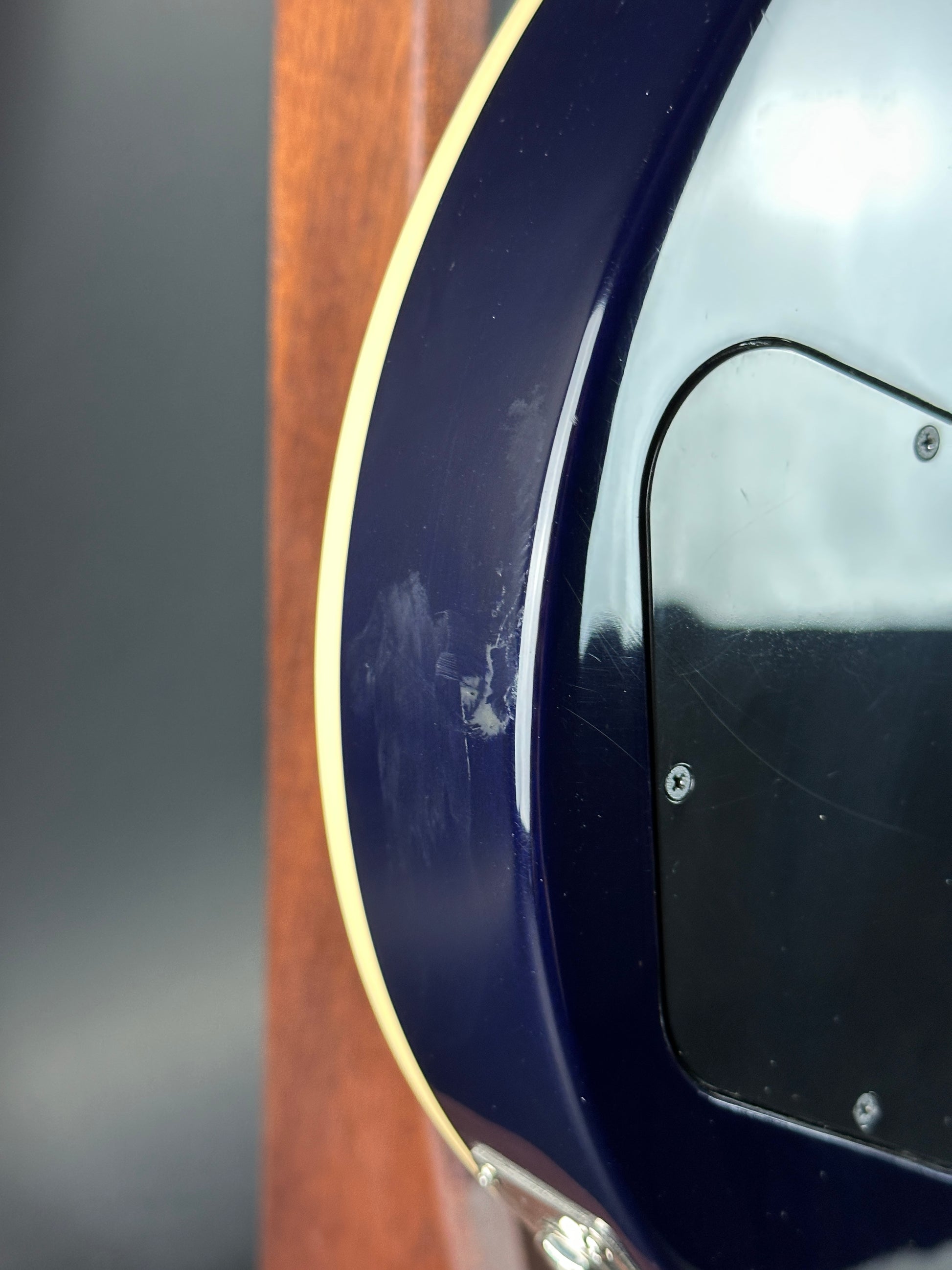 Close-up of a guitar's soundhole with a visible scratch.
