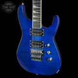 A blue electric guitar with a flamed maple top and black body contours, shown against a black background with a Tone Shop watermark in the upper left corner.