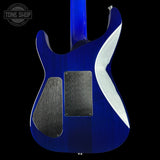 The back of a blue electric guitar with a glossy cobalt blue finish, dual black pickups, and a white accent strip on the body, shown against a black background with a Tone Shop watermark in the top left.