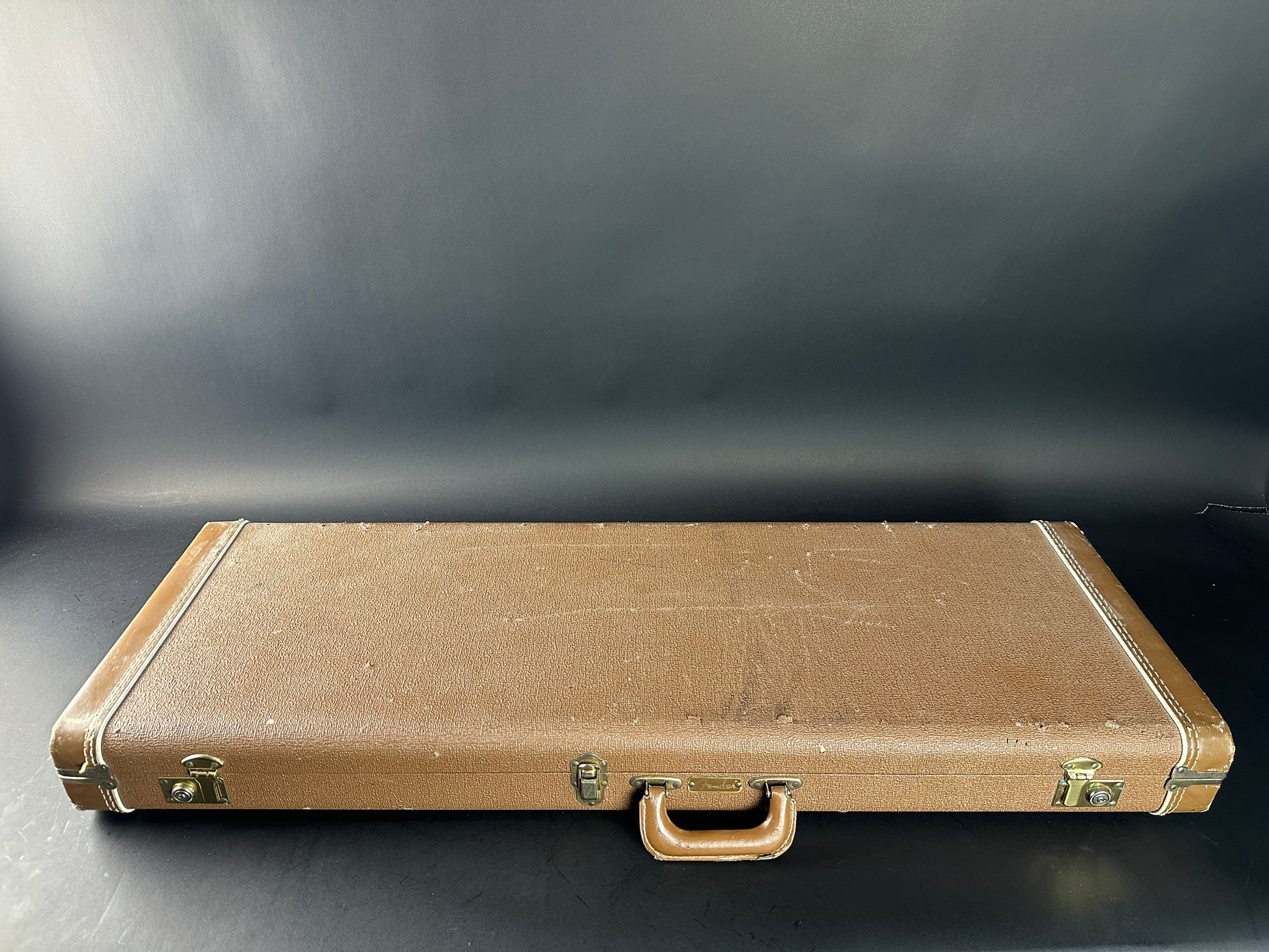 Brown vintage suitcase on a dark background