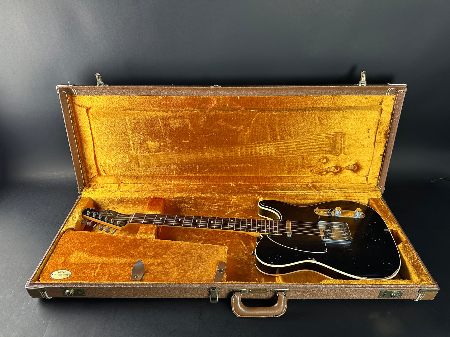 Guitar in a vintage-style case on a dark background