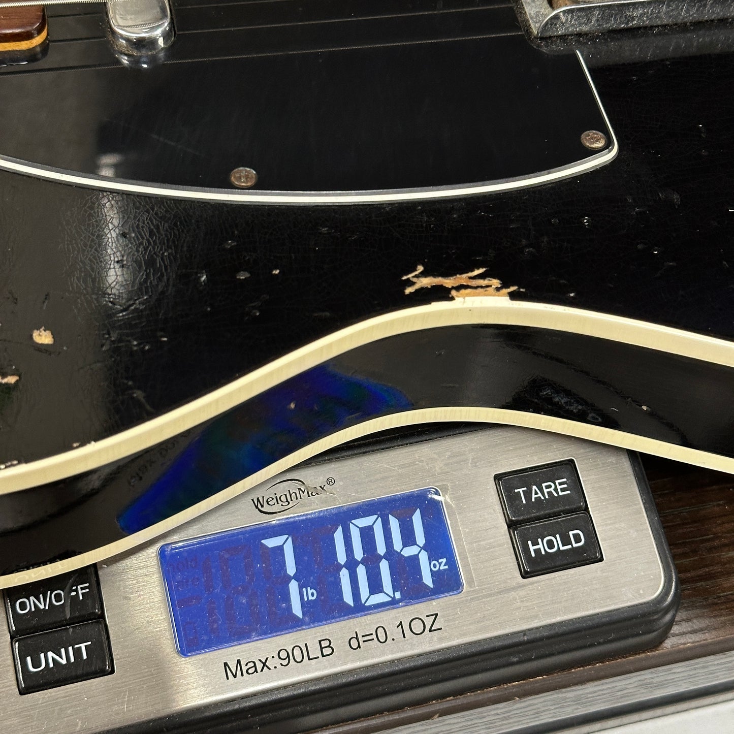 Guitar on a digital scale displaying weight in ounces