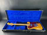 Electric guitar in a blue-lined case on a gray background