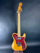 Electric guitar with a red pickguard on a dark background