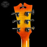 Guitar headstock with tuning pegs on a black background, featuring 'Tone Shop' branding.