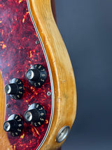 Close-up of a guitar's control panel with wood finish and tortoiseshell pattern.