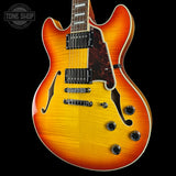 Electric guitar with a sunburst finish on a black background, featuring the Tone Shop logo.