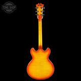 Guitar body with a gradient finish on a black background, featuring the Tone Shop logo.