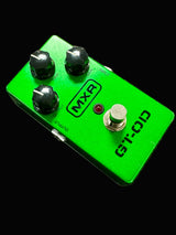 Green MXR guitar effects pedal on a textured surface
