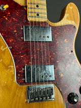 Close-up of a guitar with tortoiseshell finish and wood grain pattern.