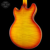 Glossy finish of a guitar body with a visible brand logo in the corner.