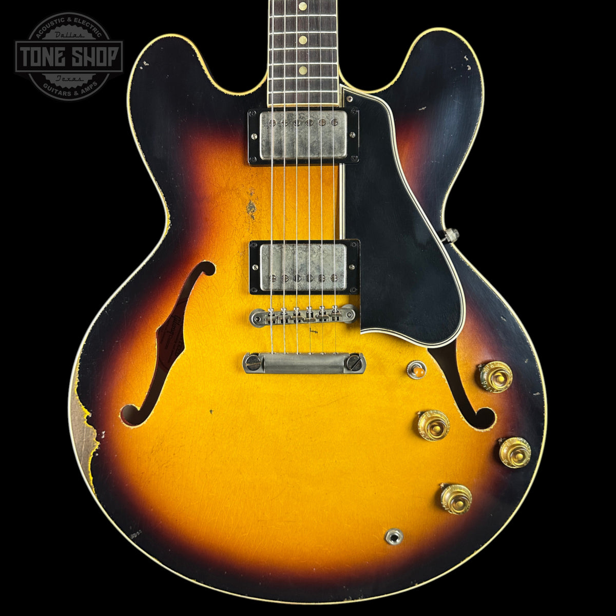 Vintage electric guitar with a sunburst finish on a black background, featuring the Tone Shop logo.
