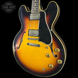 Electric guitar with a sunburst finish on a black background, featuring the Tone Shop logo.