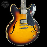 Electric guitar with a sunburst finish on a black background, featuring the Tone Shop logo.