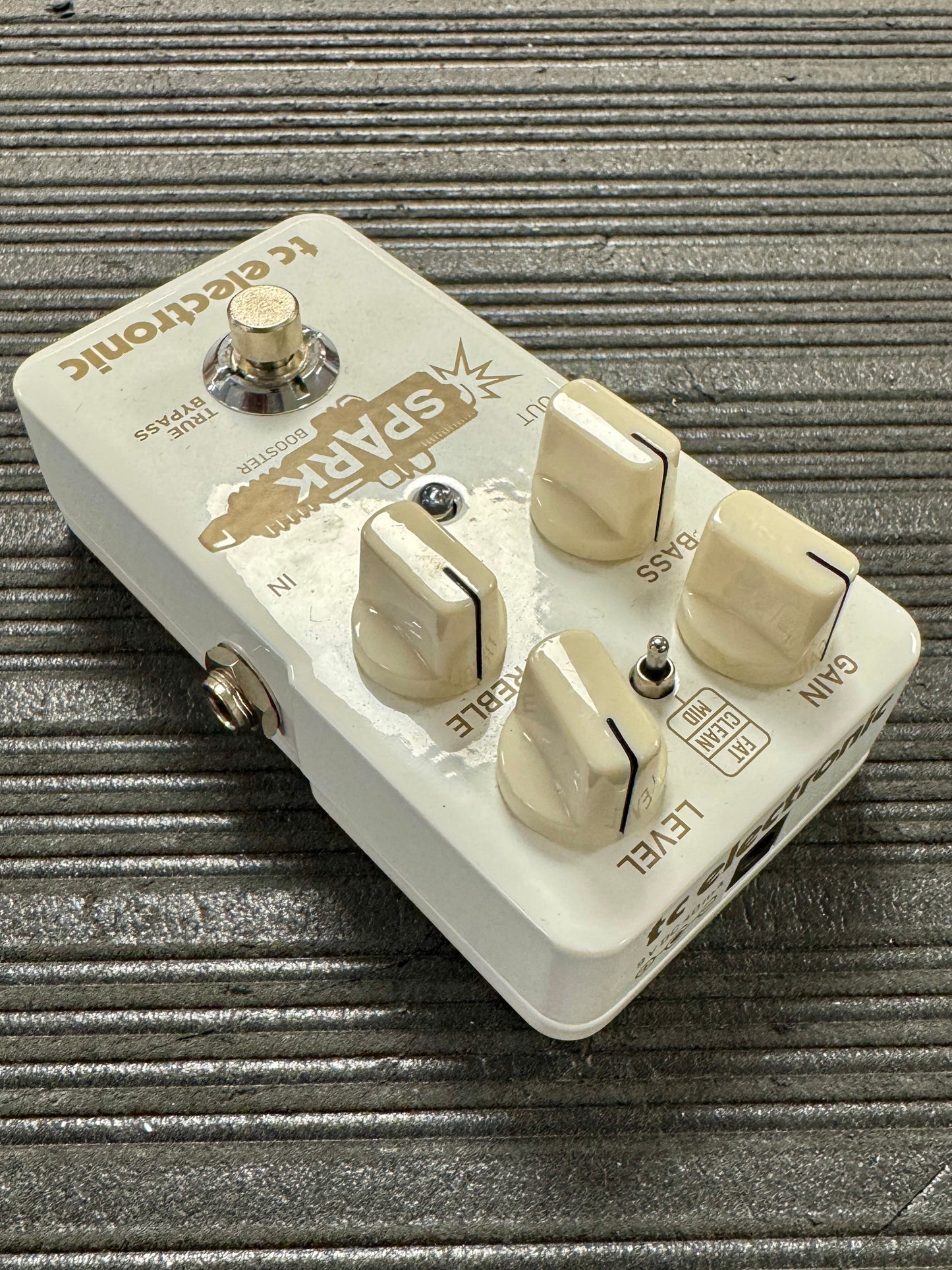 Guitar effects pedal with brand name on a textured surface