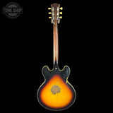 Vintage electric guitar with sunburst finish on a black background, featuring 'Tone Shop' logo.