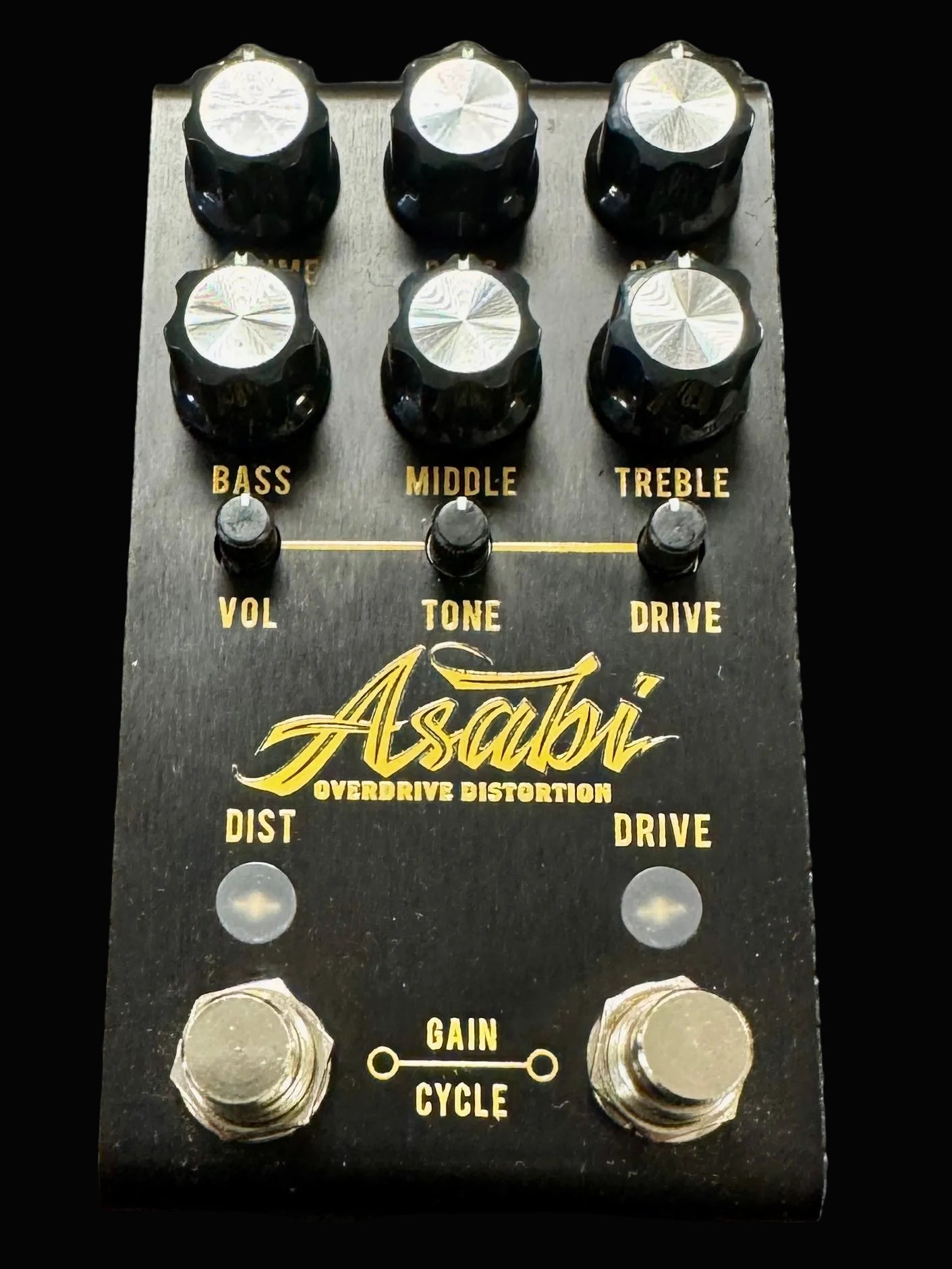 Guitar effects pedal with knobs and branding on a textured surface