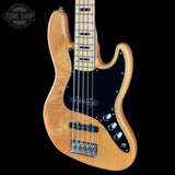 A natural wood four-string bass guitar with a black pickguard and chrome hardware, shown against a solid black background with a Tone Shop watermark in the top-left corner.