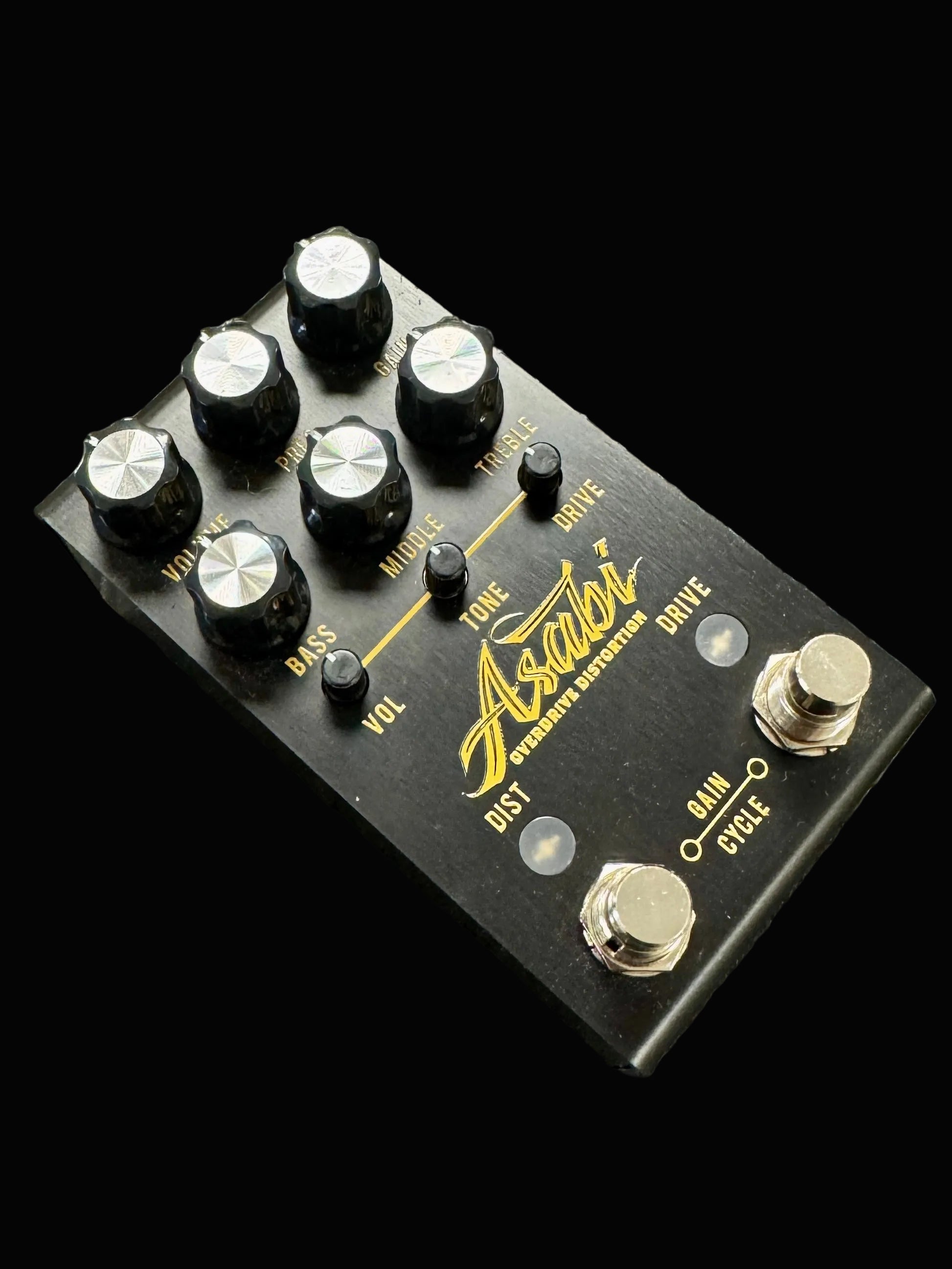 Guitar effects pedal with various knobs on a textured surface