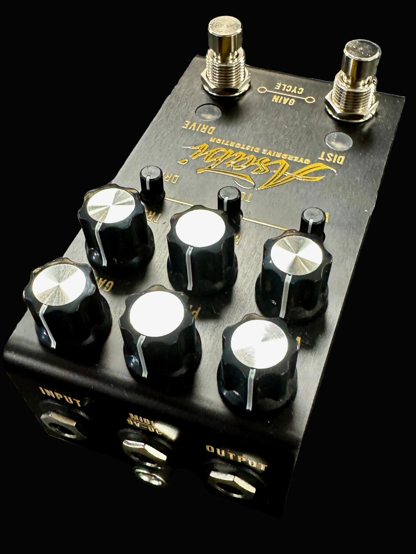 Guitar effects pedal with knobs and branding on a textured surface