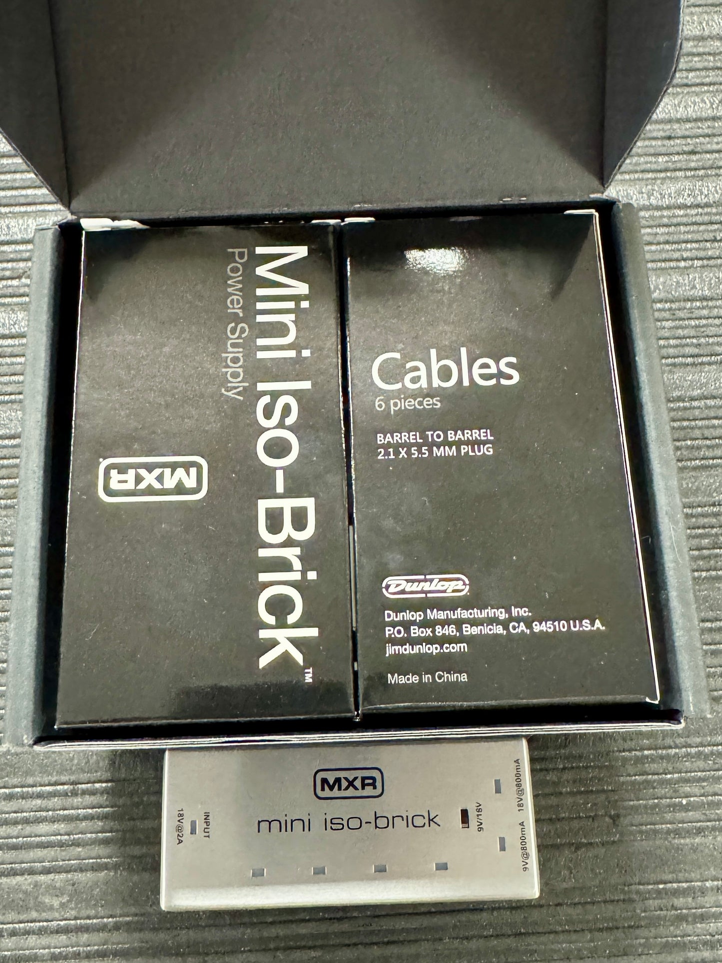 MXR mini iso-Brick power supply and cables packaging on a textured surface