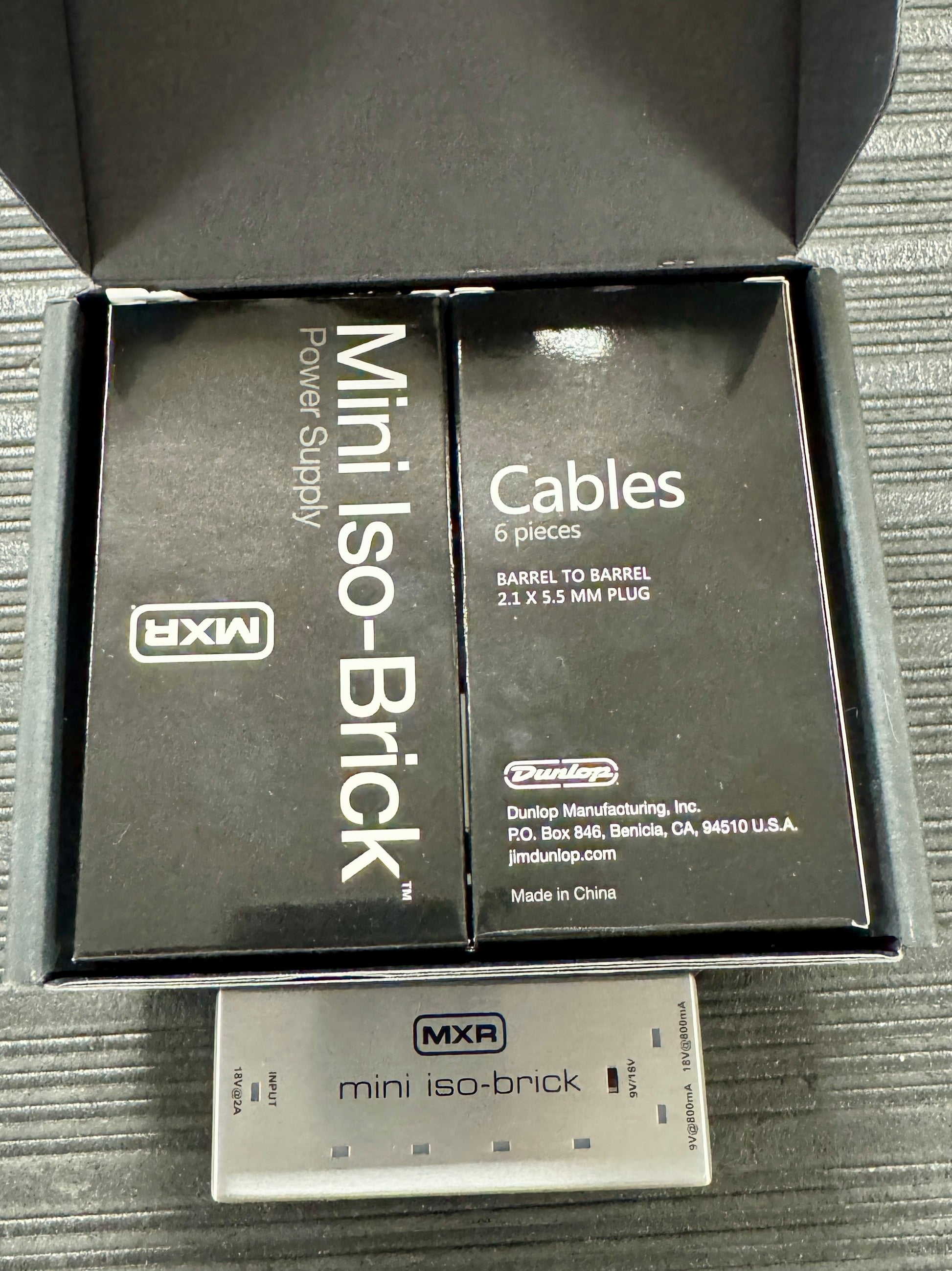 MXR mini iso-Brick power supply and cables packaging on a textured surface