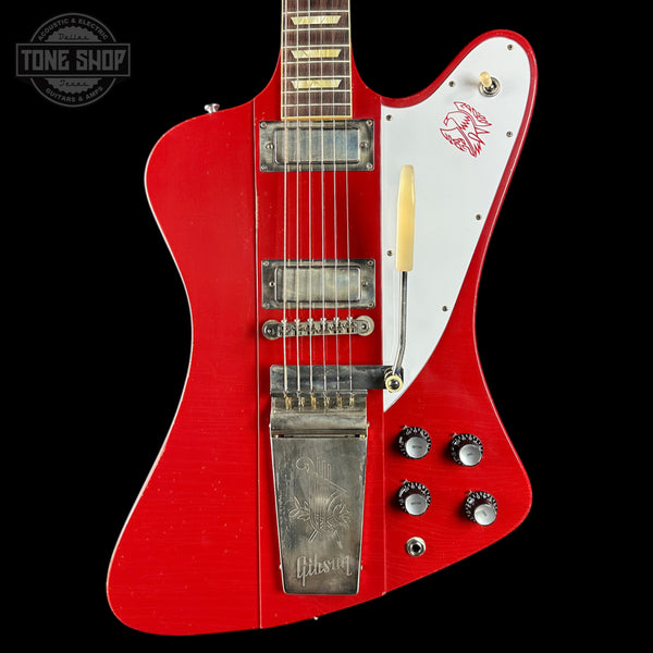 Red and white electric guitar with Gibson logo on a black background