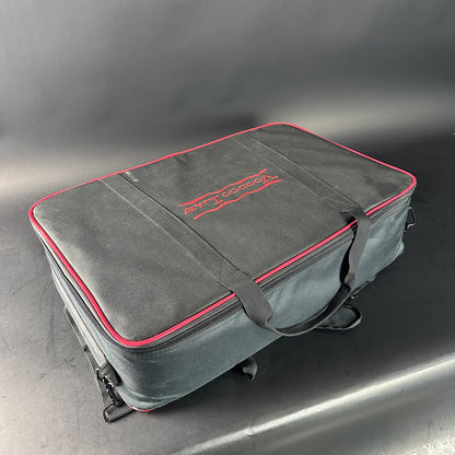 Gray carrying case with red trim and logo on a gray background