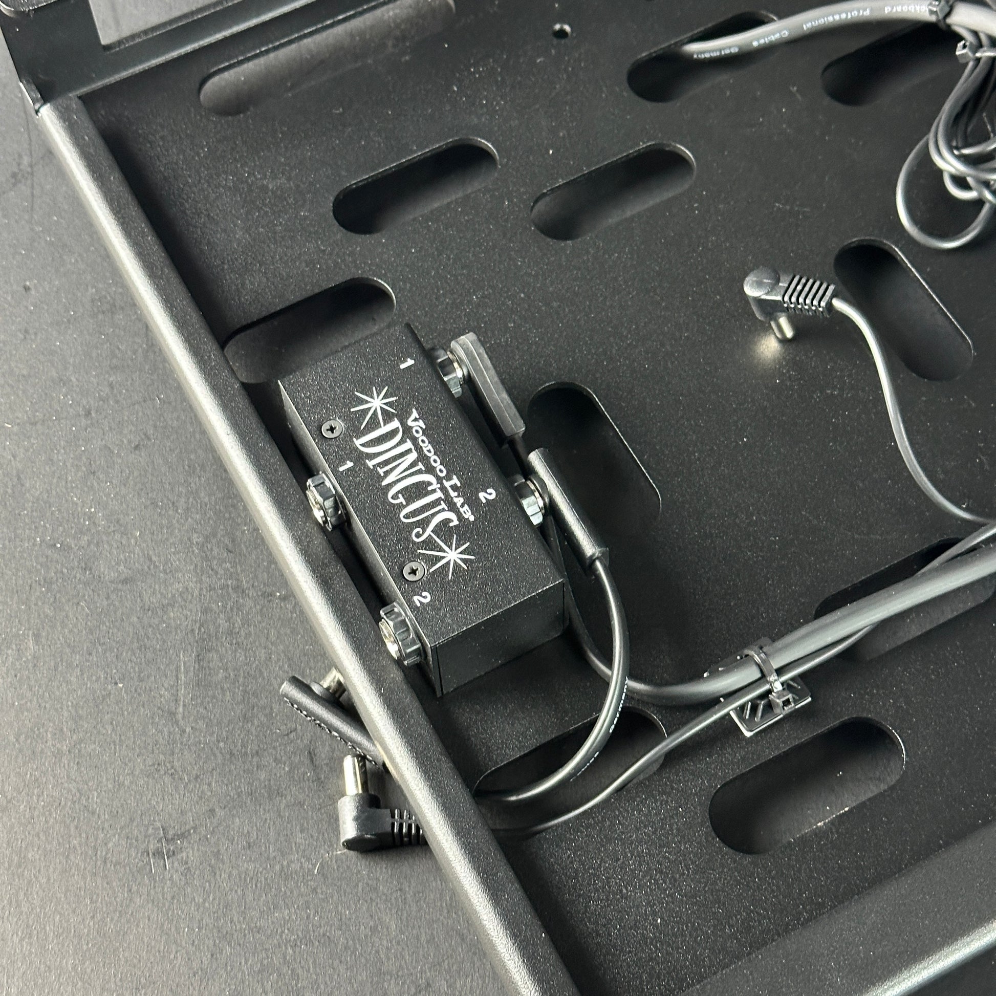 Black guitar effects pedal with visible brand logo inside a black carrying case.