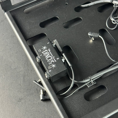 Black guitar effects pedal with visible brand logo inside a black carrying case.