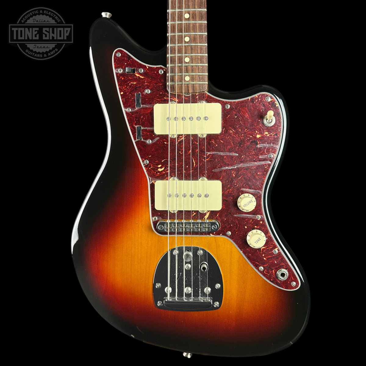 A classic electric guitar with a sunburst finish, featuring a dark red marbled pickguard and cream-colored humbucker pickups, shown against a solid black background.