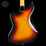 Close-up of the back of a sunburst electric guitar showing the glossy amber-to-black finish and part of the light wood neck, photographed against a black background with a Tone Shop watermark in the top-left corner.