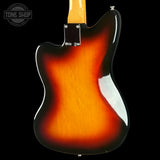 Rear view of a sunburst electric guitar body against a black background, showing the glossy orange-to-brown fade and a white pickguard.