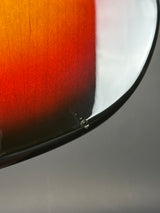 Close-up detail of a glossy curved surface showing a red-orange gradient with a black edge against a gray background.