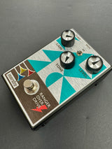 Guitar effects pedal with three knobs and a switch on a gray background