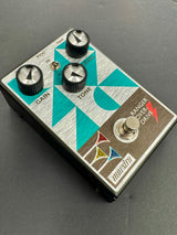 Guitar effects pedal with colorful design on a gray background