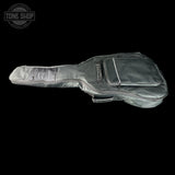 A black guitar gig bag with a silver zipper and a small front pocket, shown against a solid black background. A Tone Shop watermark is visible in the top left corner.