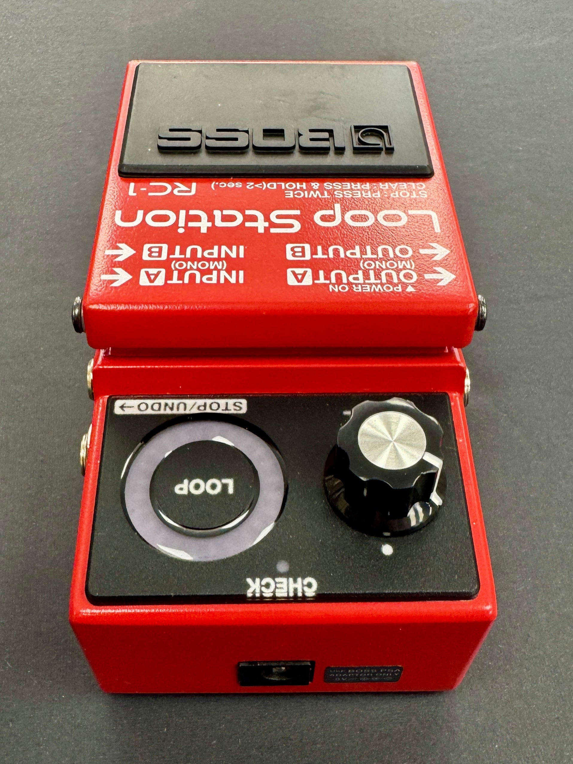 Red Boss Loop Station RC-1 guitar effects pedal on a gray background