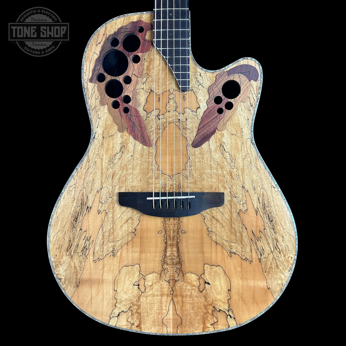 A custom acoustic-electric guitar with a highly figured maple top, featuring a symmetrical wing-like inlay design in reddish-brown and purple tones around the sound holes, set against a solid black background.
